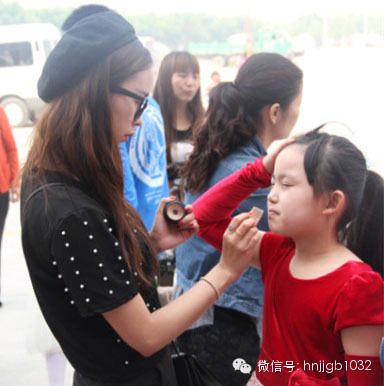 化妝老師精心為小演員整理妝容 化妝老師精心為小演員整理妝容