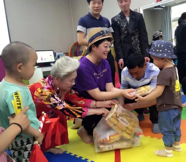 主持人周迪給孩子們分發(fā)禮物 主持人周迪給孩子們分發(fā)禮物