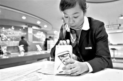 11月6日，北京移動西直門營業廳的工作人員在為顧客購買的4G手機登記。新華社發