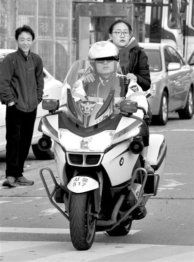 7日,首爾,警察將一名考生送抵考場。新華社發 7日,首爾,警察將一名考生送抵考場。新華社發