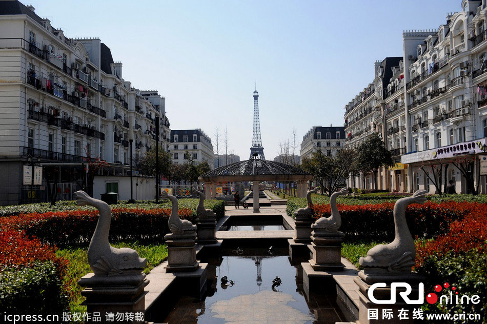 　2014年3月21日，杭州天都城，農民在山寨埃菲爾鐵塔下耕作。圖片來源：東方IC