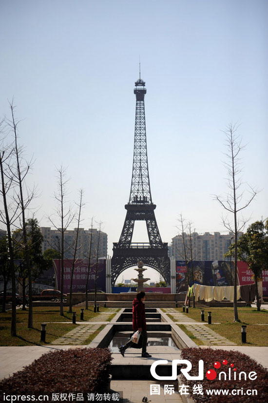 　2014年3月21日，杭州天都城，農民在山寨埃菲爾鐵塔下耕作。圖片來源：東方IC