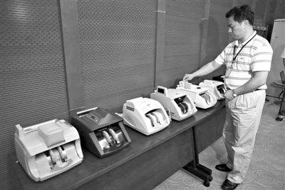 昨日，央行工作人員用各種驗(yàn)鈔機(jī)對(duì)C1F9假幣進(jìn)行測試，機(jī)器均能及時(shí)作出異常報(bào)警反應(yīng)。新京報(bào)記者 浦