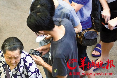 排隊的“黃?！备魇謭桃化B白紙，上面寫好了要掛號的人的信息，包括姓名、電話、要掛的科室等。穿黑白花紋衣服的老婆婆正在排隊掛號