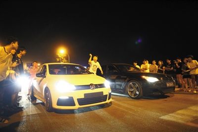 8月24日晚，東壩中街飆車現場，兩輛車并排等待出發指令，旁邊許多愛好者前來觀看比賽。新京報記者