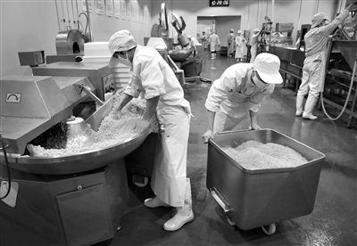 昨日，位于順義李遂開發區的慶豐包子鋪配送中心生產車間，工人們正在斬拌胡蘿卜餡料。