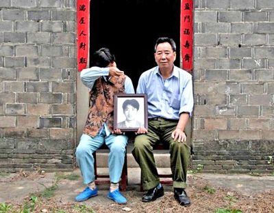 江蘇鎮江，老劉夫婦捧著獨生子的遺像在老家前留影南方都市報供圖L