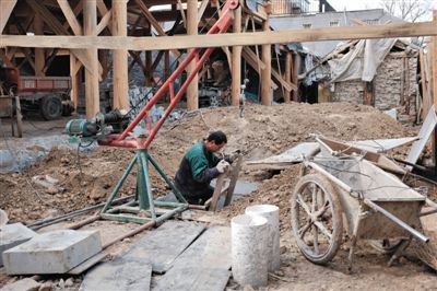 東城區北鑼鼓巷與小經廠胡同之間一處四合院內，工人進入已經挖好的地下室內施工。