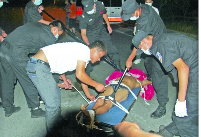 眾人合力將狂犬病發作的江某控制住。 孫東城 攝 眾人合力將狂犬病發作的江某控制住。 孫東城 攝