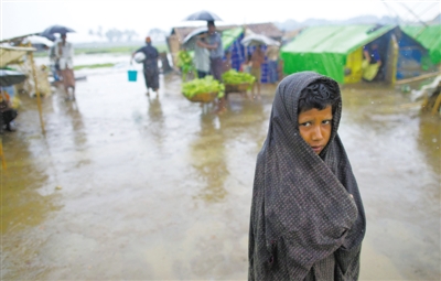5月14日，緬甸若開邦實兌難民營，羅興亞族難民在雨中行走。熱帶風(fēng)暴“馬哈森”即將登陸緬甸，這里的難民開始乘船撤離。