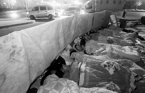 在寒冷的冬夜，為了能省點錢，方便接活，民工們仍睡在橋下。