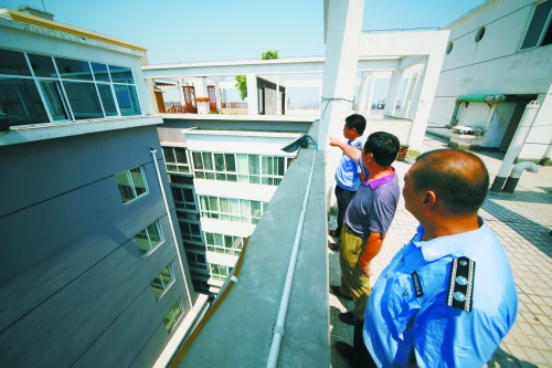 洛龍區城管執法人員到該小區的“空中花園”進行調查取證 洛龍區城管執法人員到該小區的“空中花園”進行調查取證