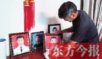 沉浸在悲痛之中的魯有海,擦拭著孩子的遺照 沉浸在悲痛之中的魯有海,擦拭著孩子的遺照