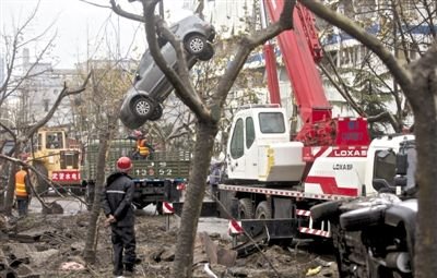 輸油管道爆炸后，搶修人員將被炸毀的車輛運出現場。