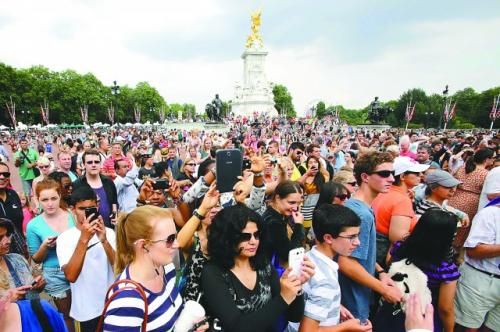 7月23日,在英國倫敦白金漢宮外,民眾們爭相閱讀“王室寶寶”出生的正式公告。