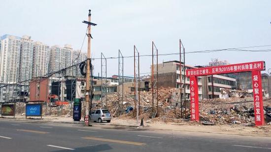 015年5月31日,在社區(qū)干部的帶頭拆遷下,親賢社區(qū)的“城中村改造”拉開(kāi)帷幕。由于前期“清產(chǎn)核資”及補(bǔ)償標(biāo)準(zhǔn)等因素,拆遷改造工作推進(jìn)并不順利。圖為位于體育西路東側(cè)集體所有的商鋪率先被拆遷完畢,用于遮擋的圍擋正在施工中。(拍攝:2015年9月16日)