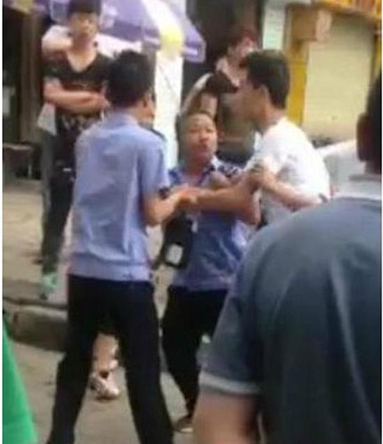 付某（右）與城管執(zhí)法人員廝打在一起。