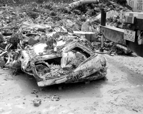 7月2日，新密市區，暴雨沖倒圍墻，一輛汽車被砸成“鐵餅”