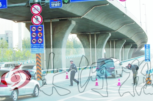 交警在東風路從北向南上橋口處擺上反光錐,間歇放行 交警在東風路從北向南上橋口處擺上反光錐,間歇放行