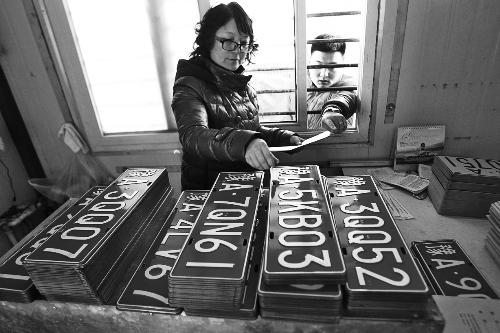 鄭州市車管所工作人員正忙著把新制作的車牌發給等待的車主 鄭州市車管所工作人員正忙著把新制作的車牌發給等待的車主