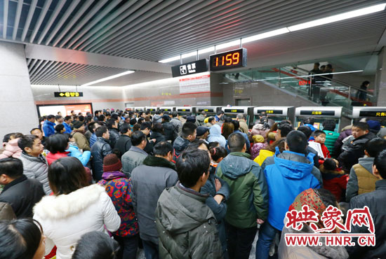 地鐵開通首日，上午十一點五十九分，紫荊山地鐵站售票機前擠滿了買票的市民。