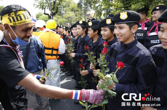 2013年12月03日,曼谷總理府與曼谷警署允許反政府示威民眾進入,雙方進入暫時“停戰”狀態迎接泰王生日。曼谷警察總署,女警們手持鮮花送給反政府示威民眾。圖片來源:Manish Swarup/東方IC