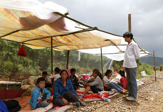 暴雨馬上來臨，村民們在簡易帳篷下躲雨。澎湃新聞 程藝輝 圖