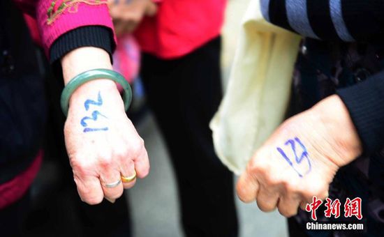 圖為10月28日，在江西九江市一家羊絨皮草服裝服飾博覽會現(xiàn)場，老人們正在頂著寒風(fēng)排隊(duì)等待領(lǐng)取10元代金劵。