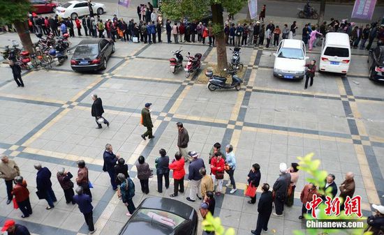 圖為10月28日，在江西九江市一家羊絨皮草服裝服飾博覽會現(xiàn)場，老人們正在頂著寒風(fēng)排隊(duì)等待領(lǐng)取10元代金劵。