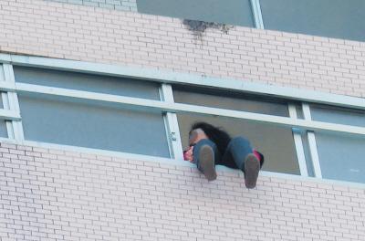 28樓的窗臺上坐著一名女子，其兩條腿耷拉在室外，不停地擺動。