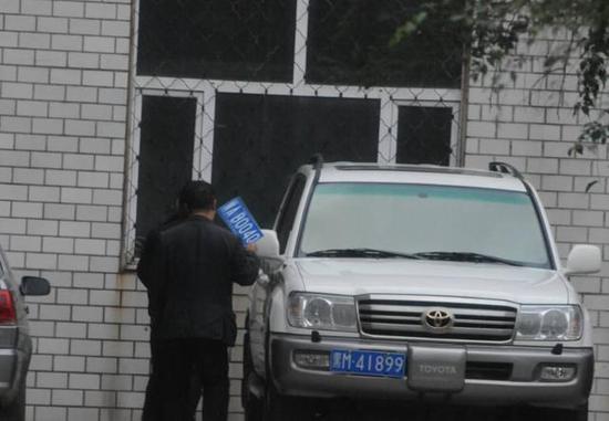 程父與程的“司機(jī)”在居住小區(qū)內(nèi)將黑AB0040車牌更換為黑M41899車牌，倆車牌號(hào)均為空號(hào)