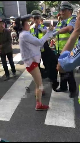 女子不愿交20元罰款 當街上演“脫衣秀”阻攔執法